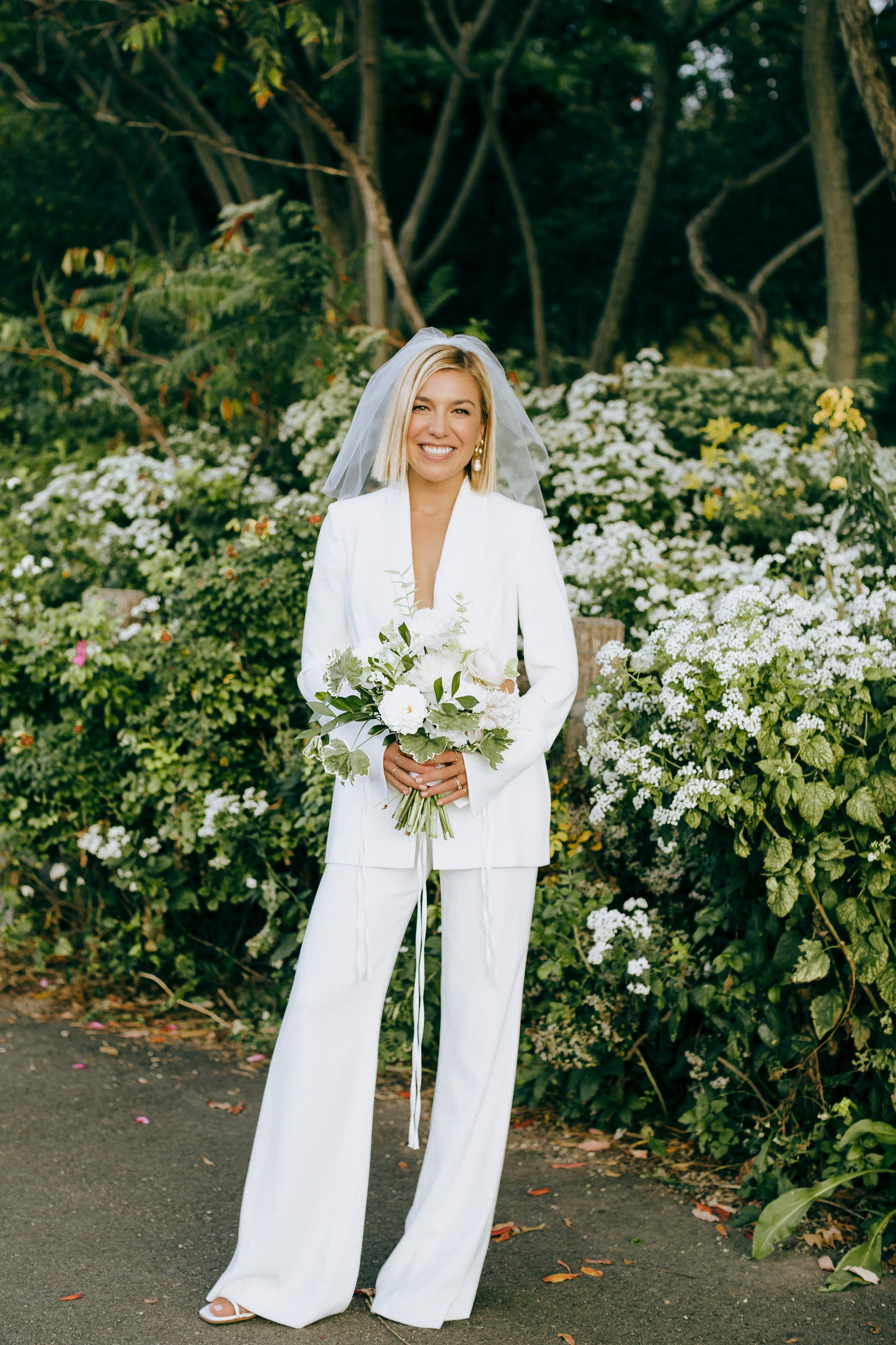 chic white bridal jumpsuit and small birdcage shoulder length bridal veil