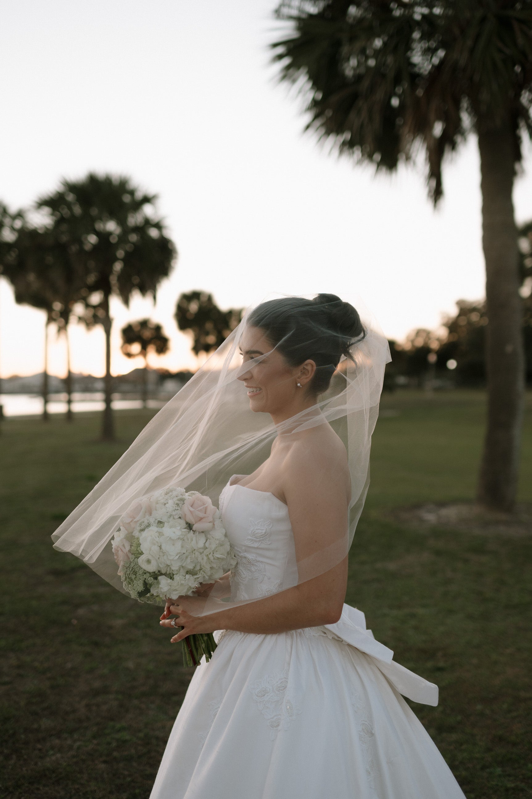 soft ivory face veil over bride holding round white and blush bouquet in California golf course