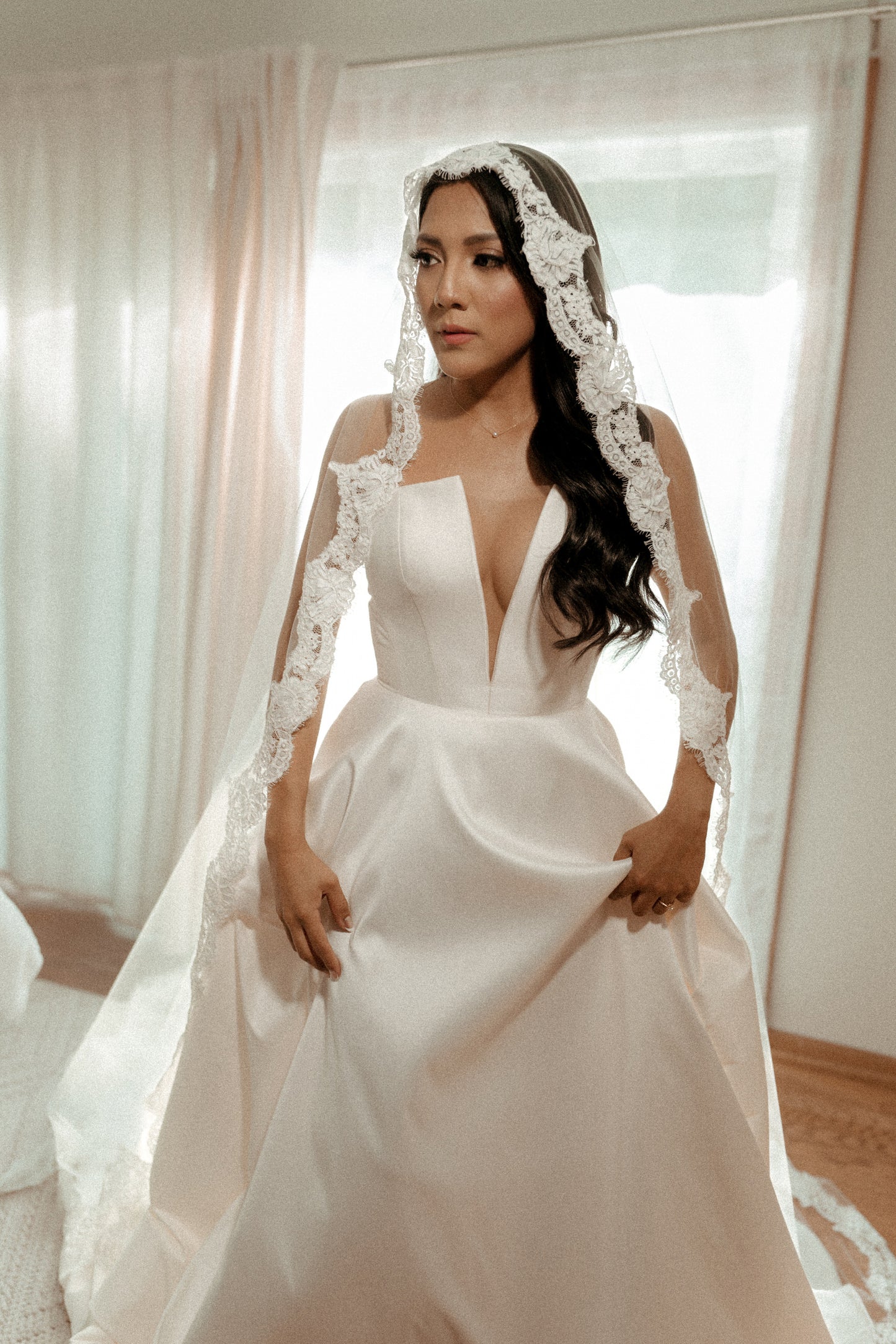 stunning Latina bride with deep V notched gown and lace mantilla wedding veil