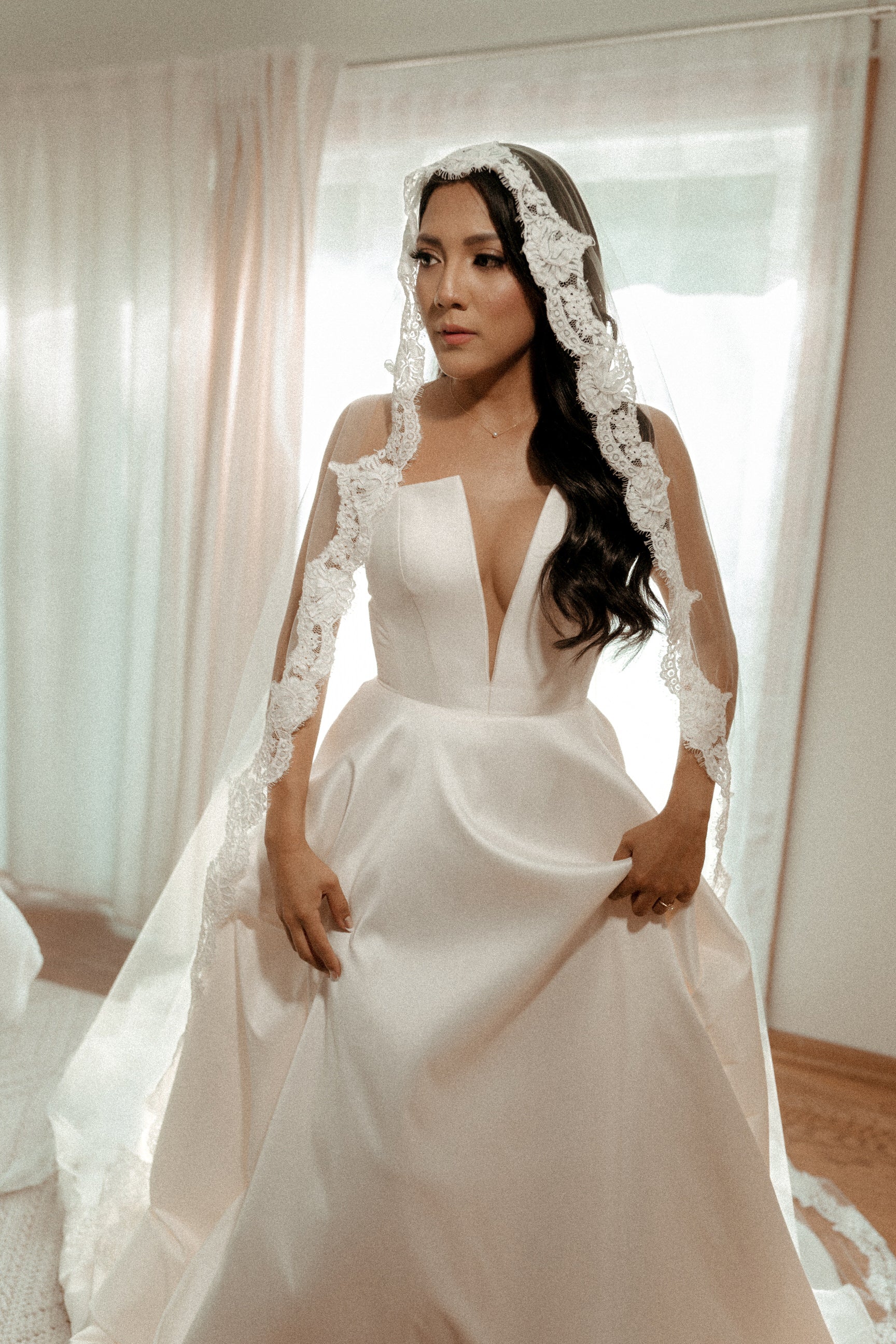 stunning Latina bride with deep V notched gown and lace mantilla wedding veil