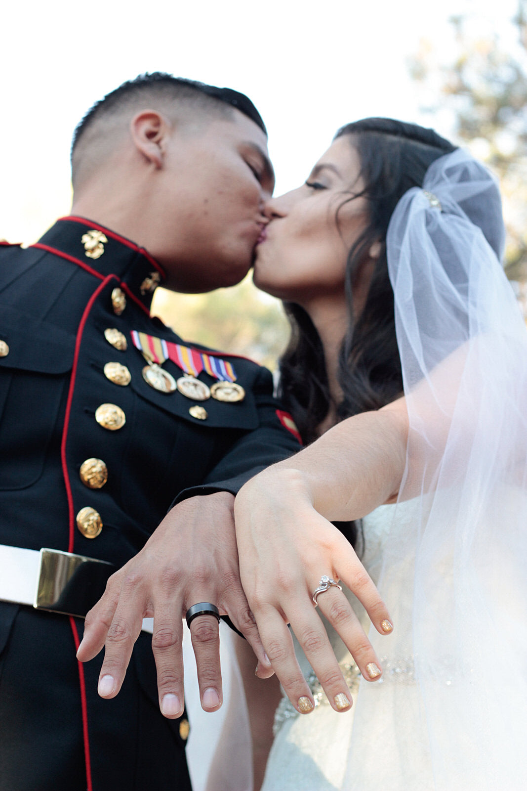 couple showing off wedding rings with bride wearing a two layer Juliet cape wedding veil in white