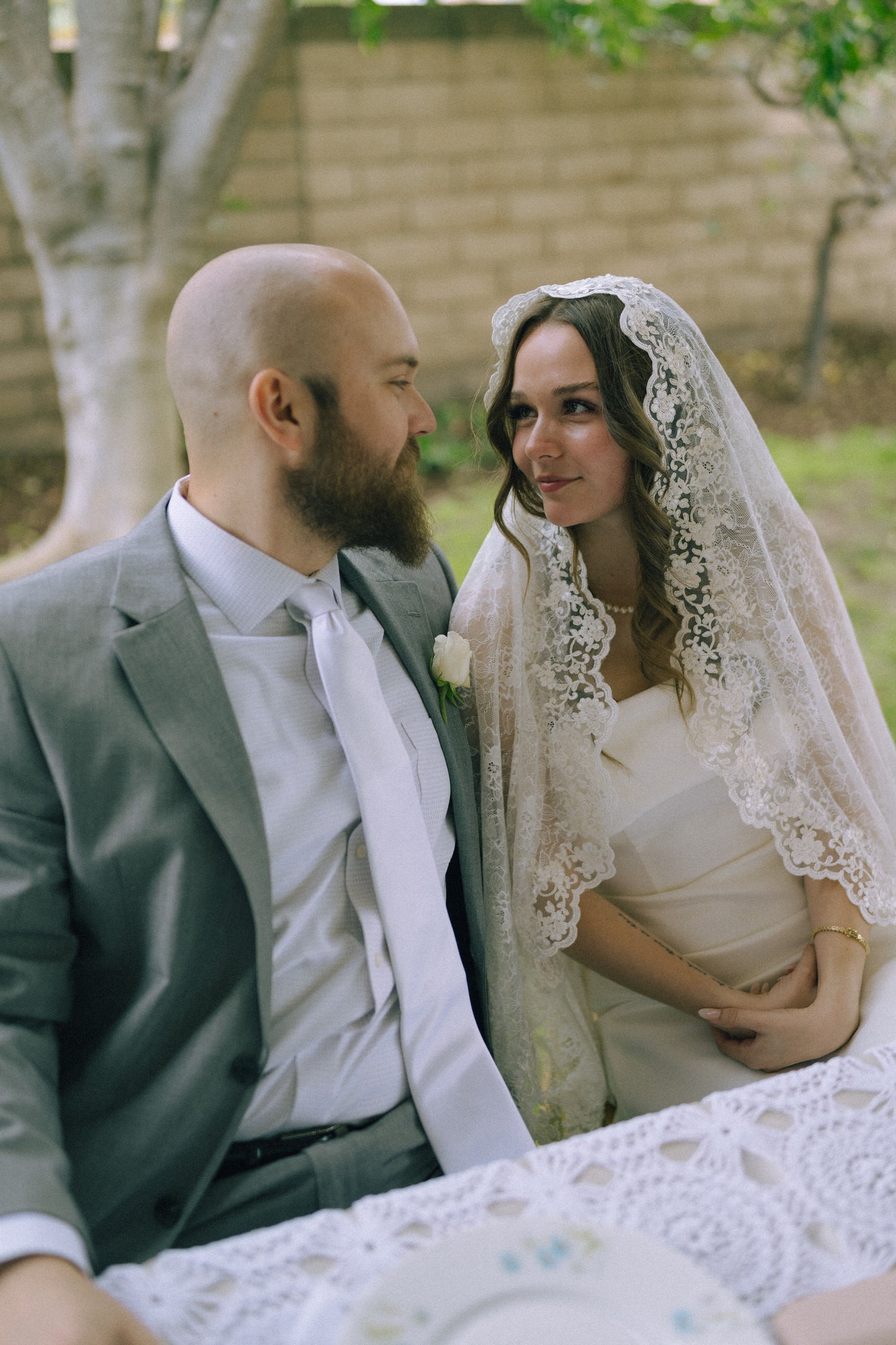 creamy ivory mantilla bridal veil with lace trim over curled downed hair