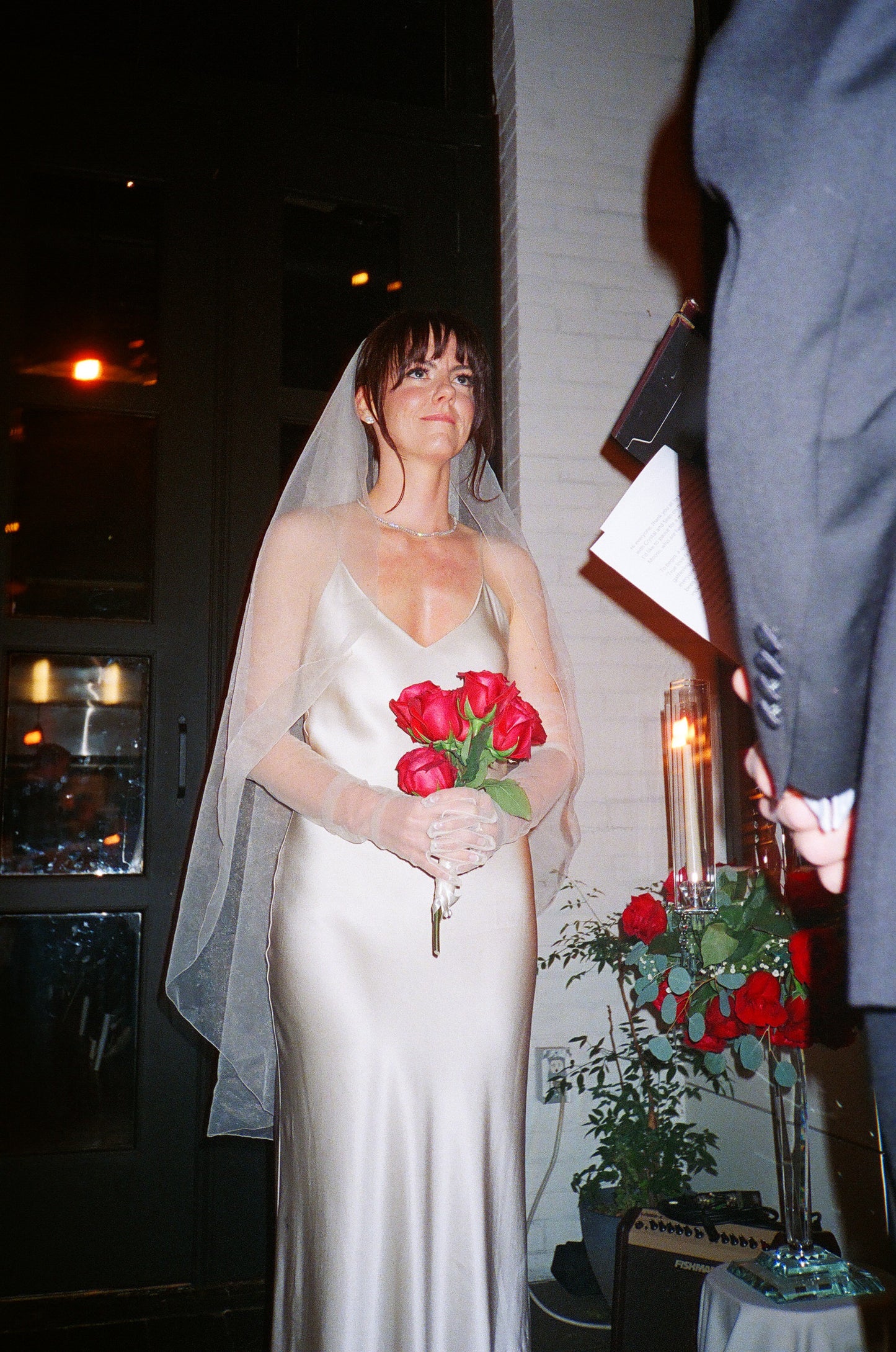 cascade fingertip veil on bride with bangs holding red roses