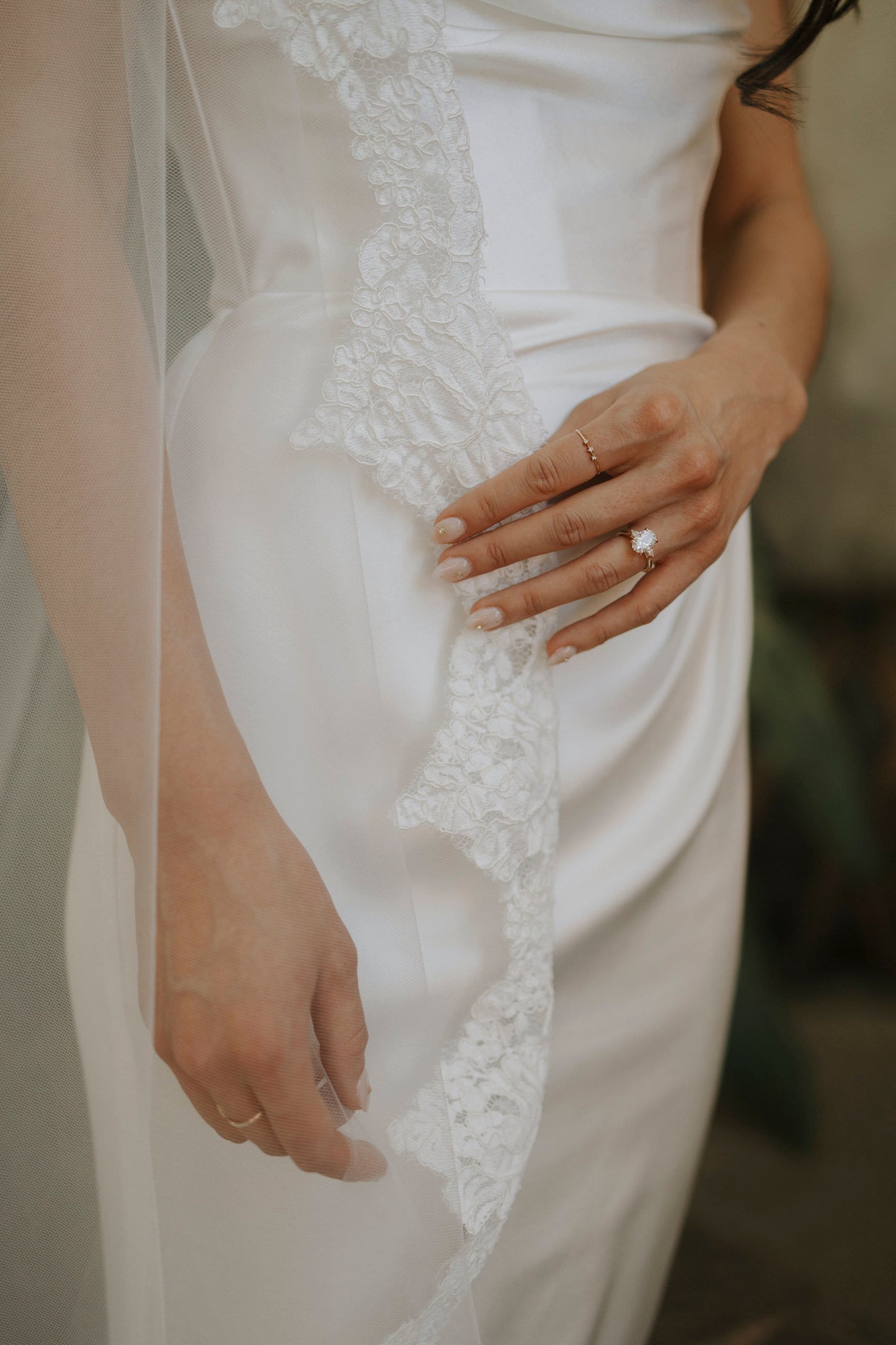 romantic and classic ivory wedding veil lace trim on bride with neutral nails and large engagement wedding ring