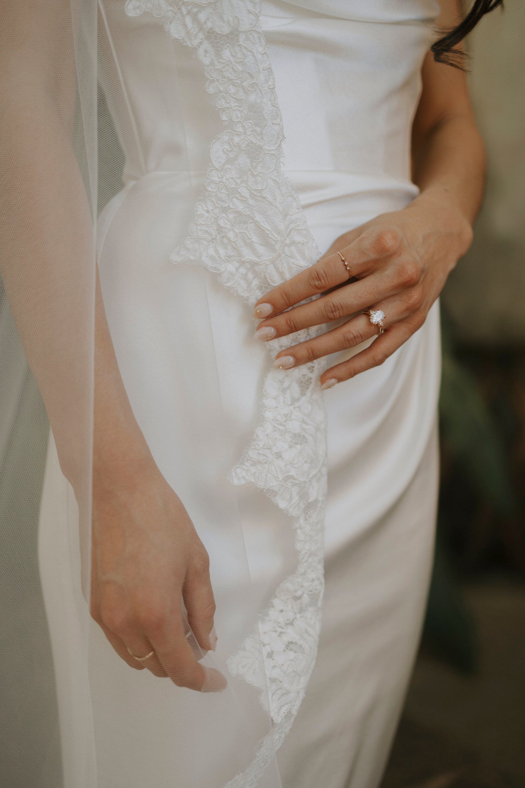 romantic and classic ivory wedding veil lace trim on bride with neutral nails and large engagement wedding ring