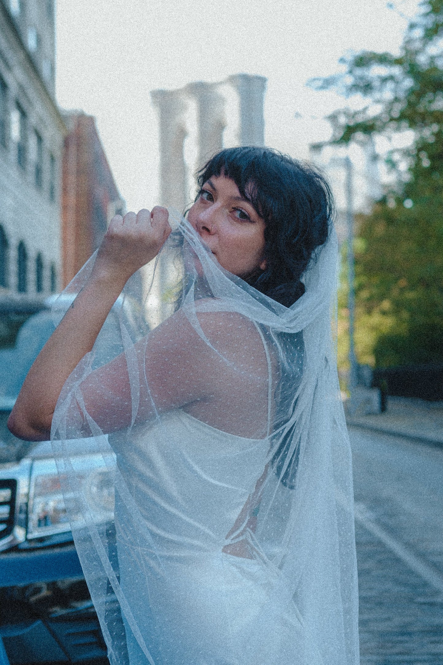 chic sophisticated city bride in Swiss dot textured wedding veil with simple corset back sheath gown