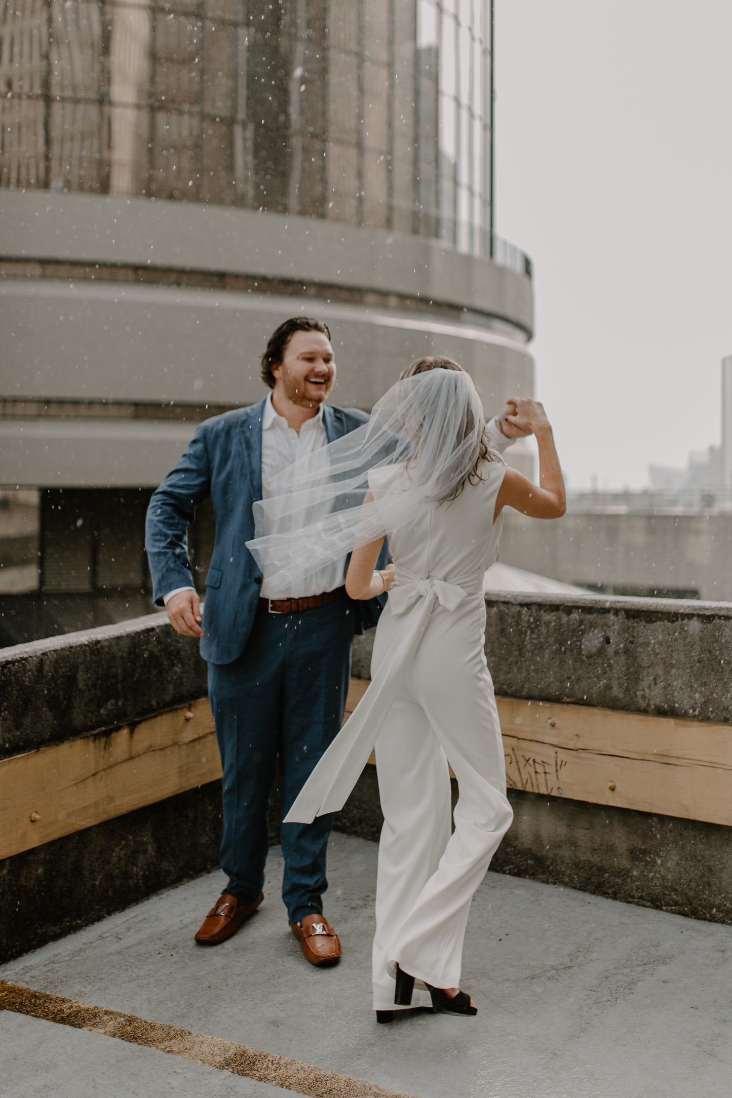 rooftop rainy wedding with couple dancing as bride wear fingertip length embroidered wedding veil with custom phrase