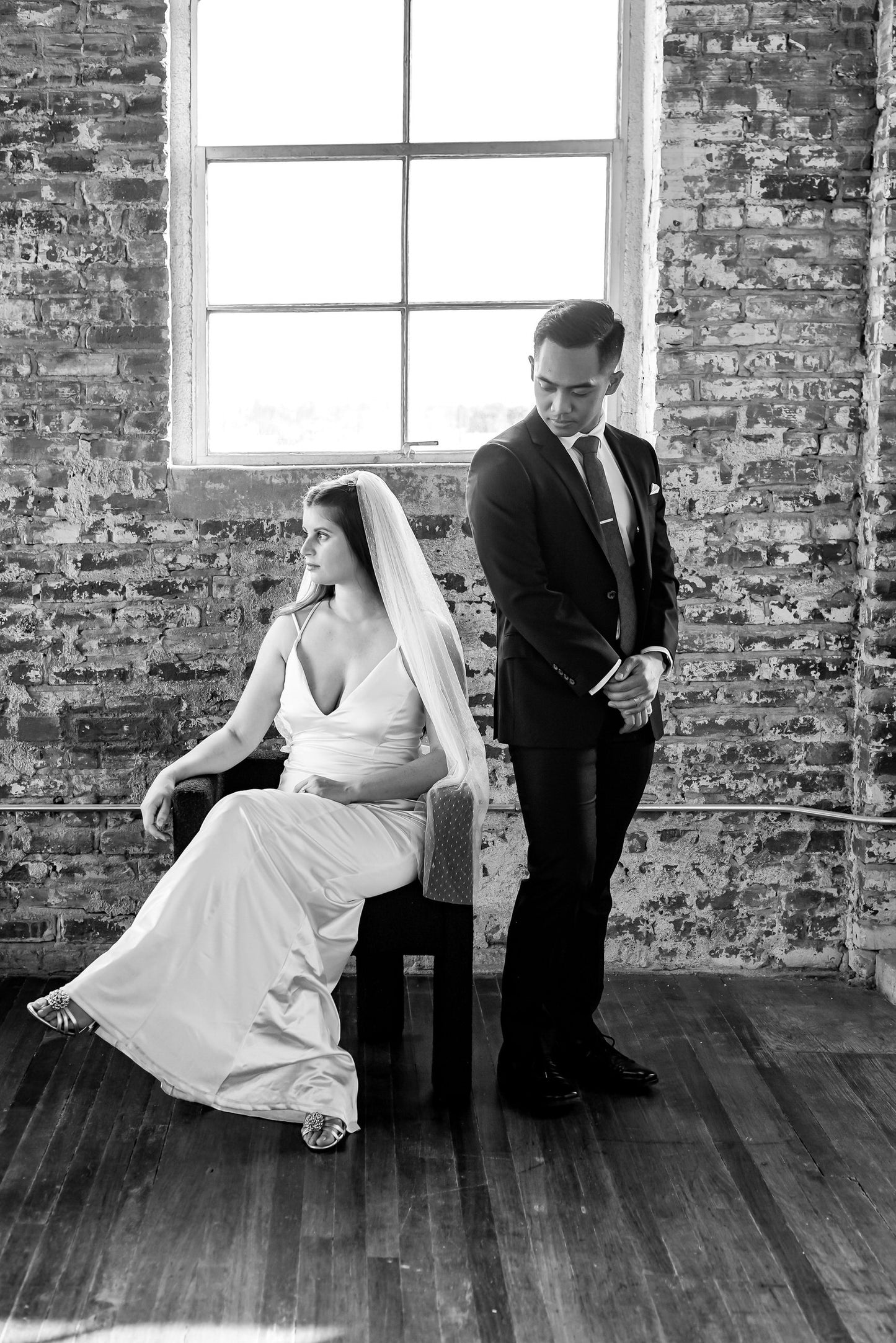 downtown industrial themed wedding with bride sitting in fingertip length Point d' Esprit dotted bridal veil next to groom