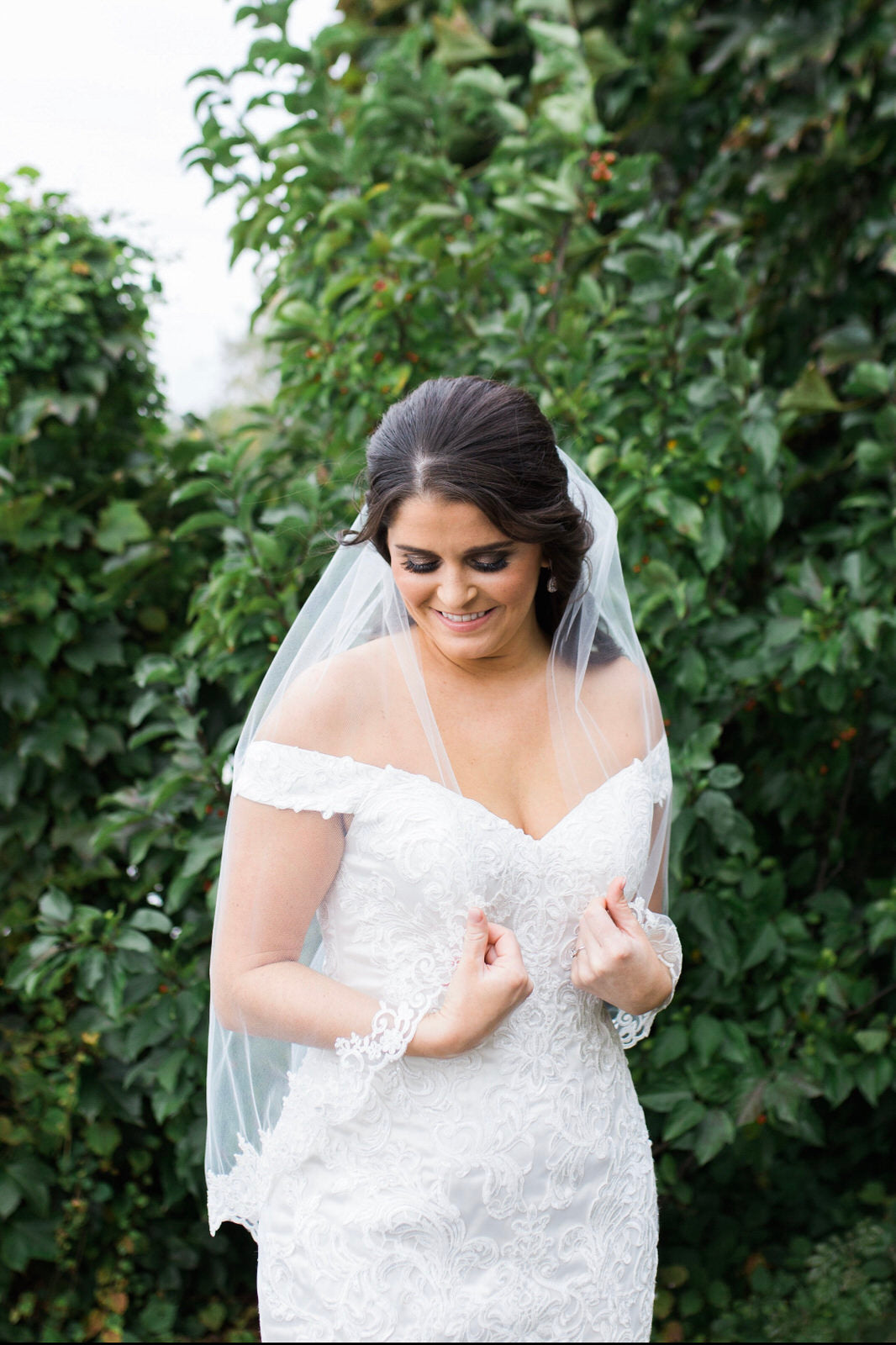 bride in waist length veil with lace in half down hairstyle
