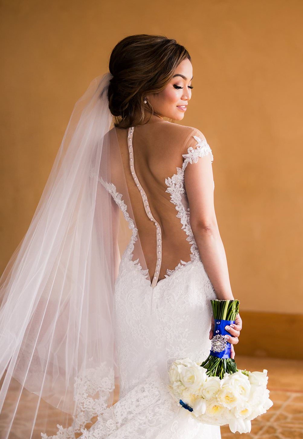 two tier wedding veil over low bun and sheer back gown