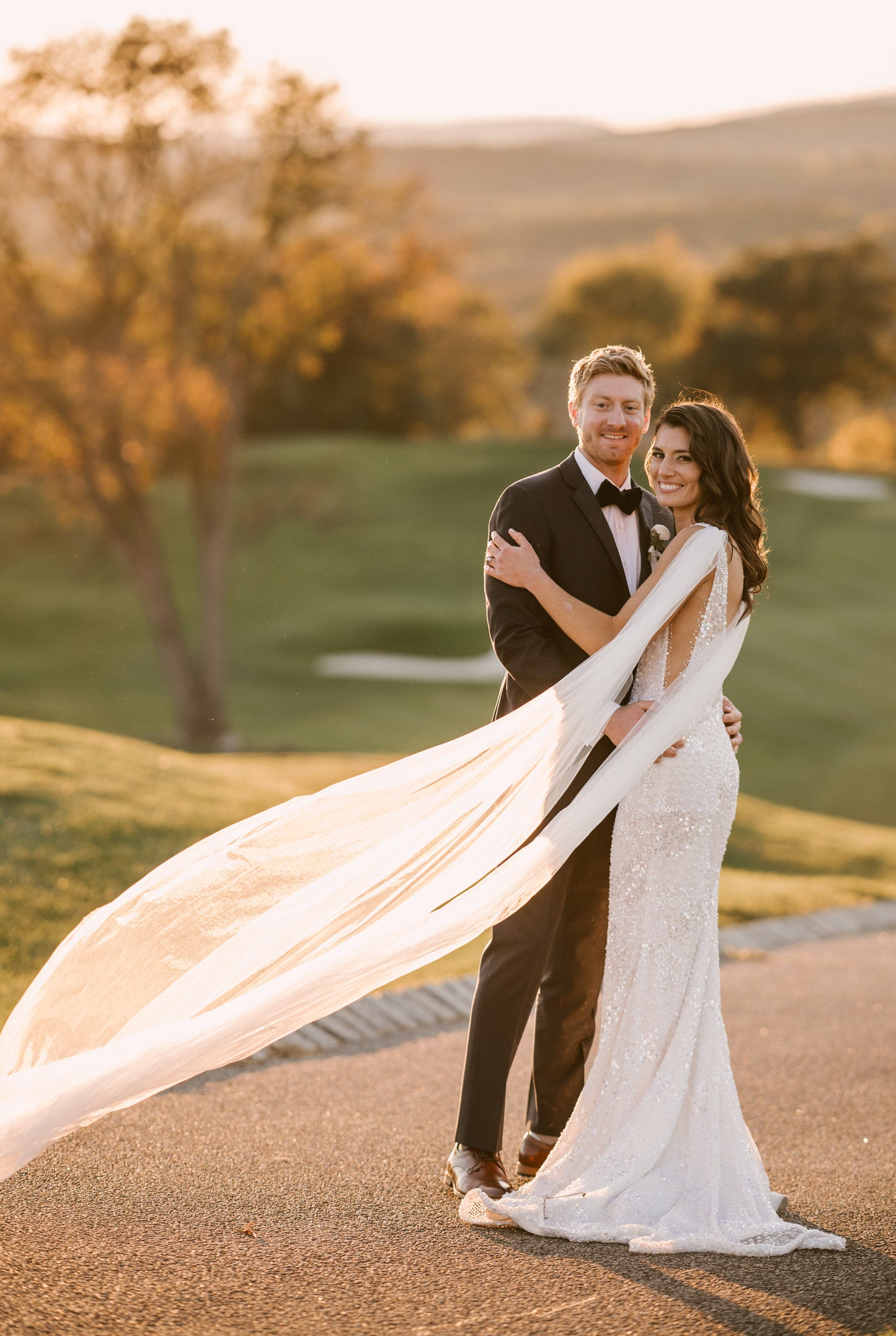 outdoor golf course wedding with bride wearing romantic long cathedral length light ivory bridal wing set and beaded side cutout wedding dress