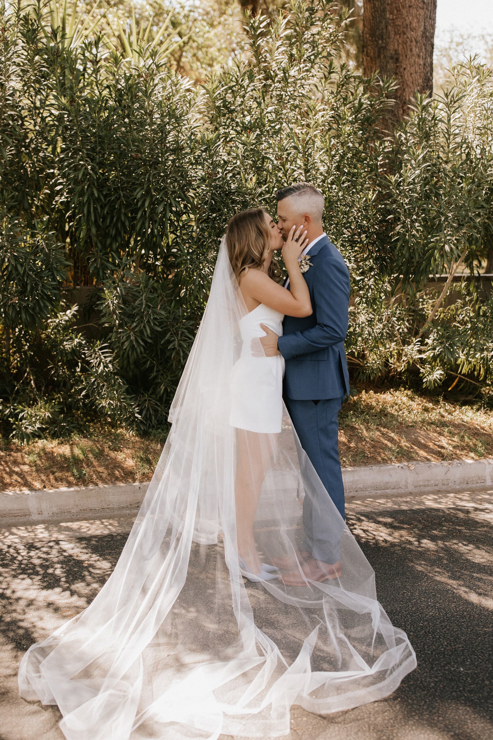 bride and groom kissing with long horsehair ribbon edged chapel veil