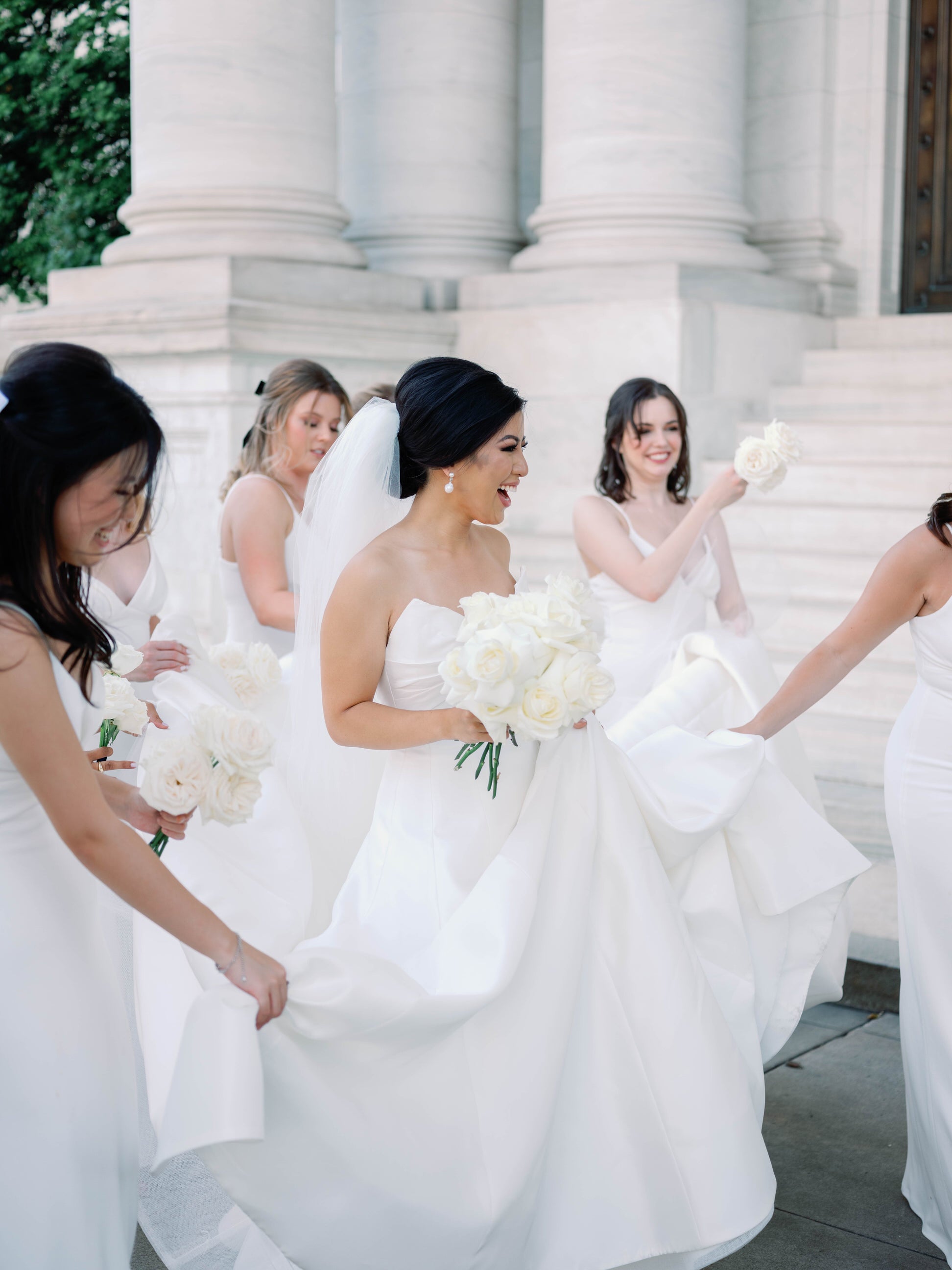 https://www.oneblushingbride.net/cdn/shop/articles/bridesmaids_in_white_dresses_helping_bride_in_long_cathedral_length_wedding_veil.jpg?v=1664558836