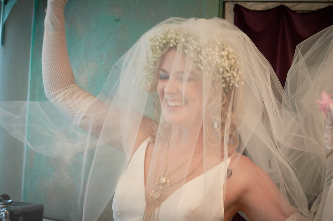 free spirited bride in blusher wedding veil with crown of baby's breath in curly hair