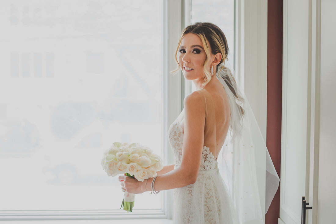 bride wearing low ponytail and pearl studded veil wrap