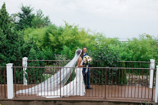 long rhinestone cathedral length bridal veil on bride crossing bridge