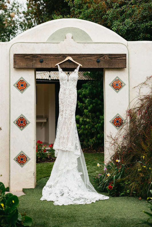 hacienda adobe wedding venue with tile decorated arch and hanging lace wedding dress