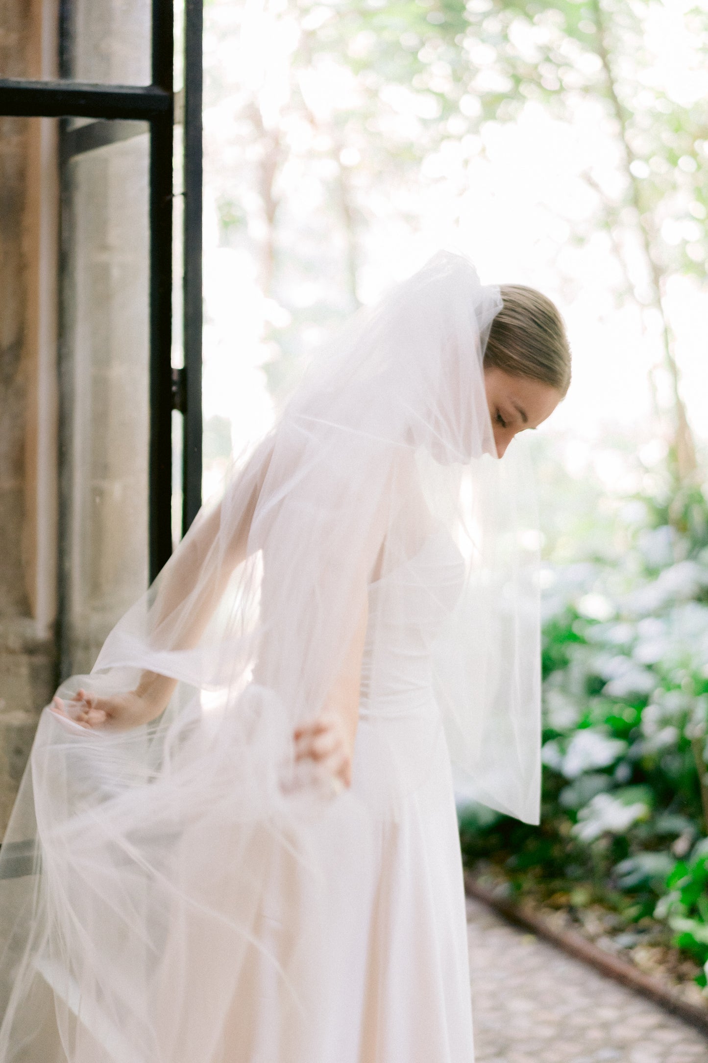 timeless elegant long wedding veil with simple raw edge over bride's chic updo