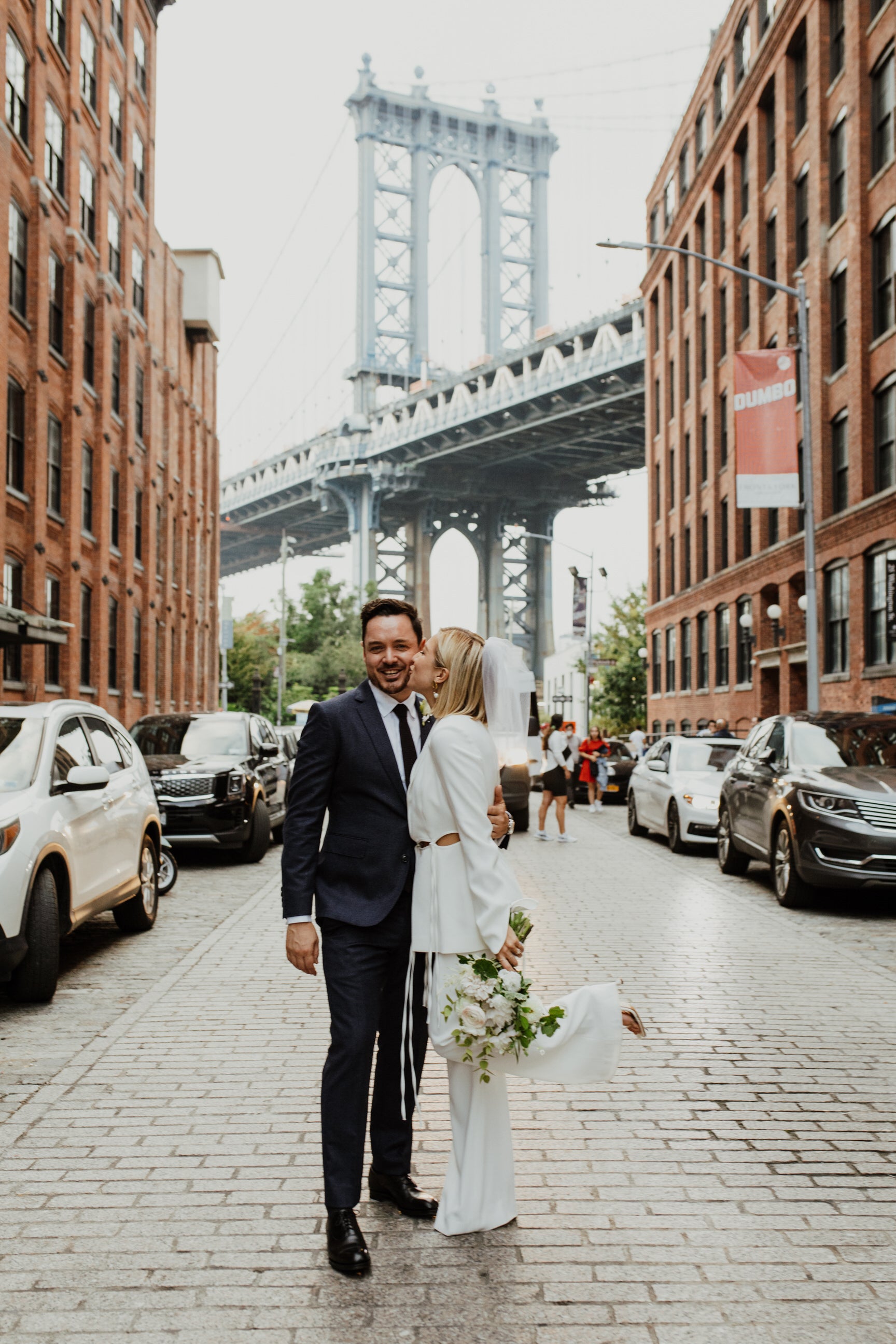 sophisticated bride with bob wearing a white birdcage wedding veil in front of Brooklyn bridge