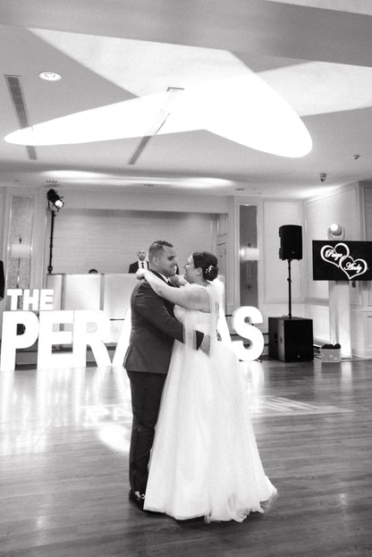 bride and groom dance with bride wearing tulle shoulder bows on her spaghetti strap bridal gown 