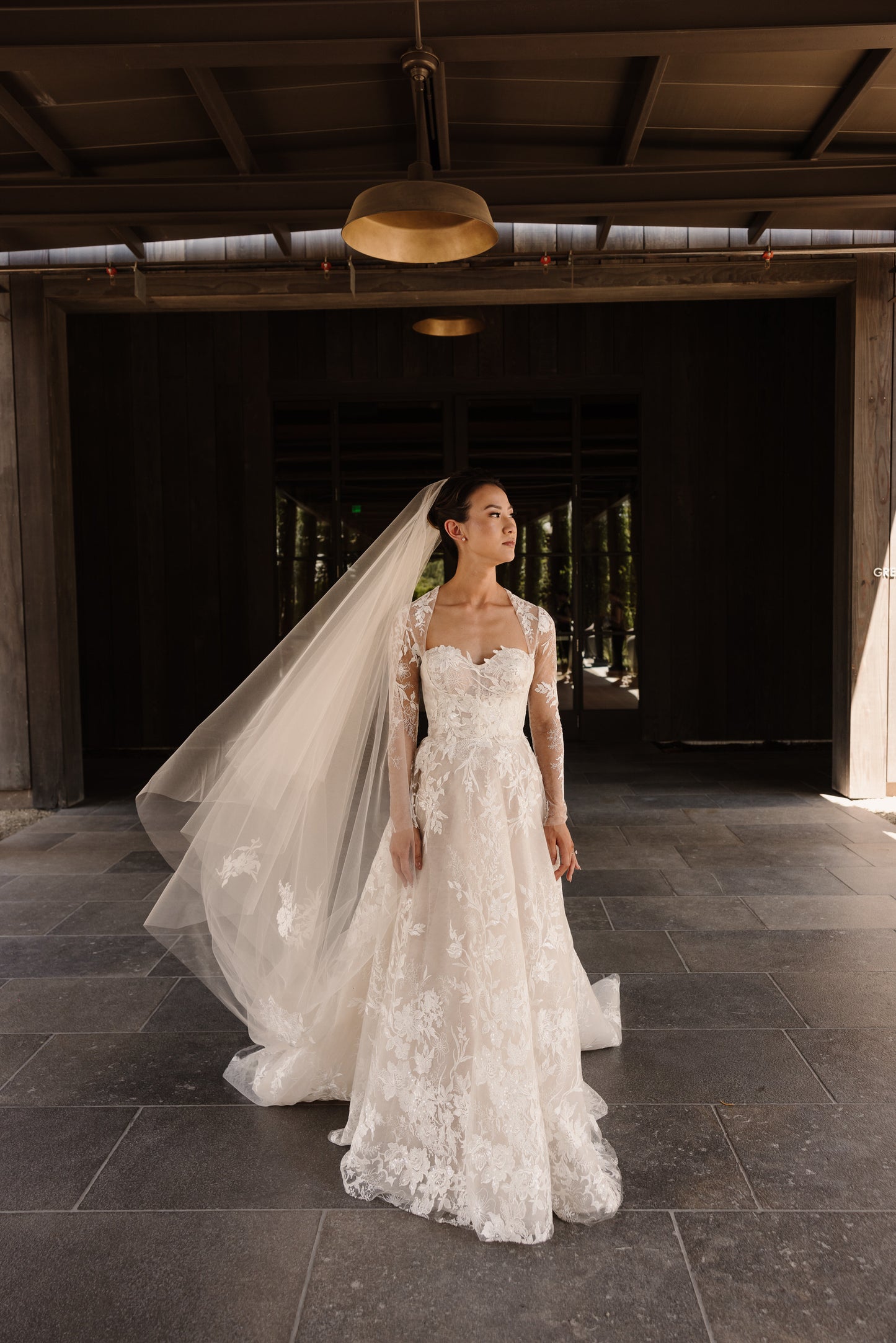 elegant and classy bride in blush gown with lace appliquéd long 120 inch veil over her updo