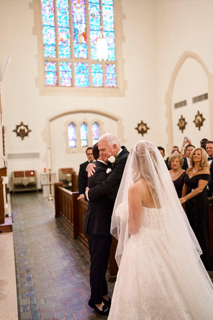 elegant bride wearing a cascade drop long veil with scattered resin dew drops in church