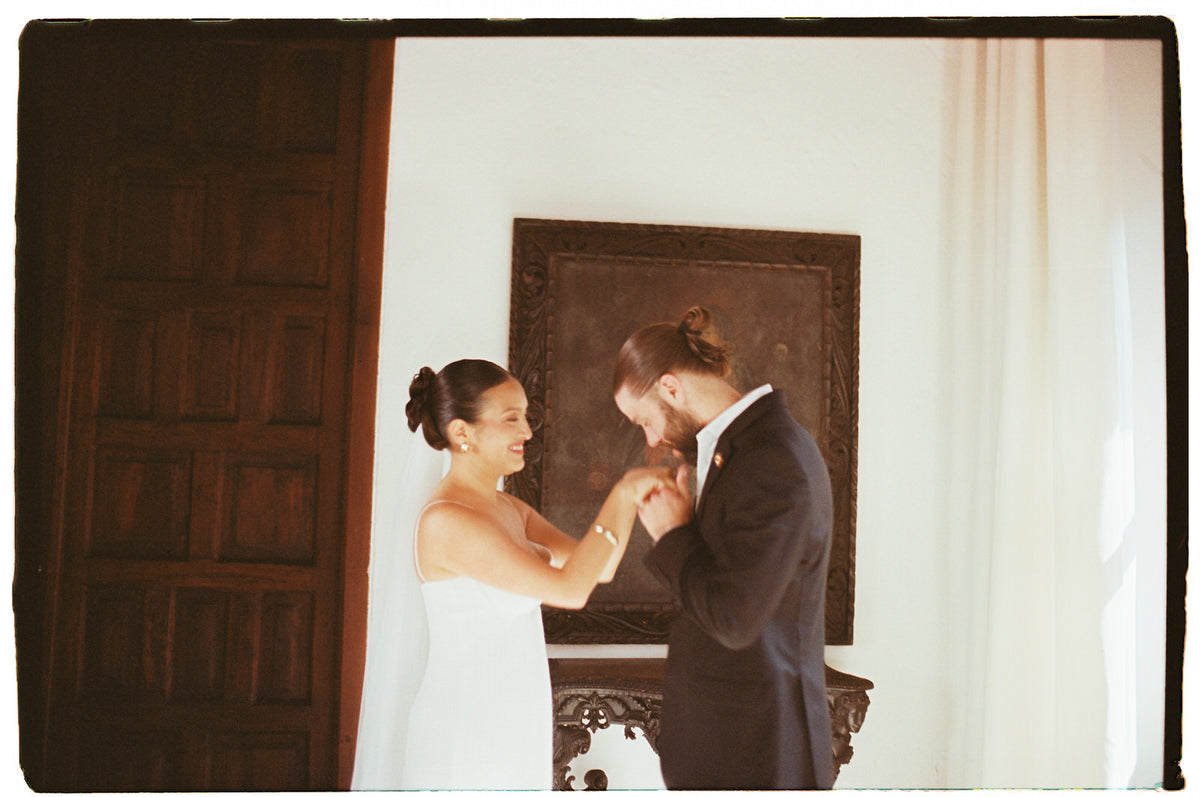 Load video: bride and groom in desert with Colombian bride wearing updo with long simple soft ivory bridal veil