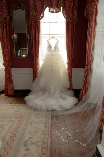 extra long embroidered wedding veil with custom text and ruffled wedding dress in regency inspired hotel room