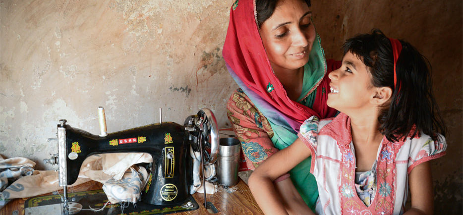 woman and daughter at sewing machine in India 