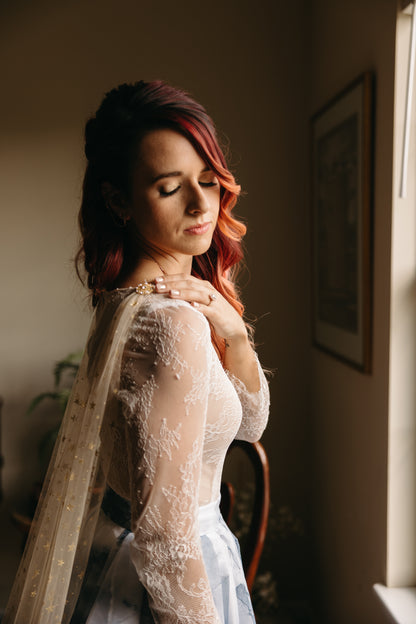 redhead bride wearing gold bridal cape on shoulders and lace top