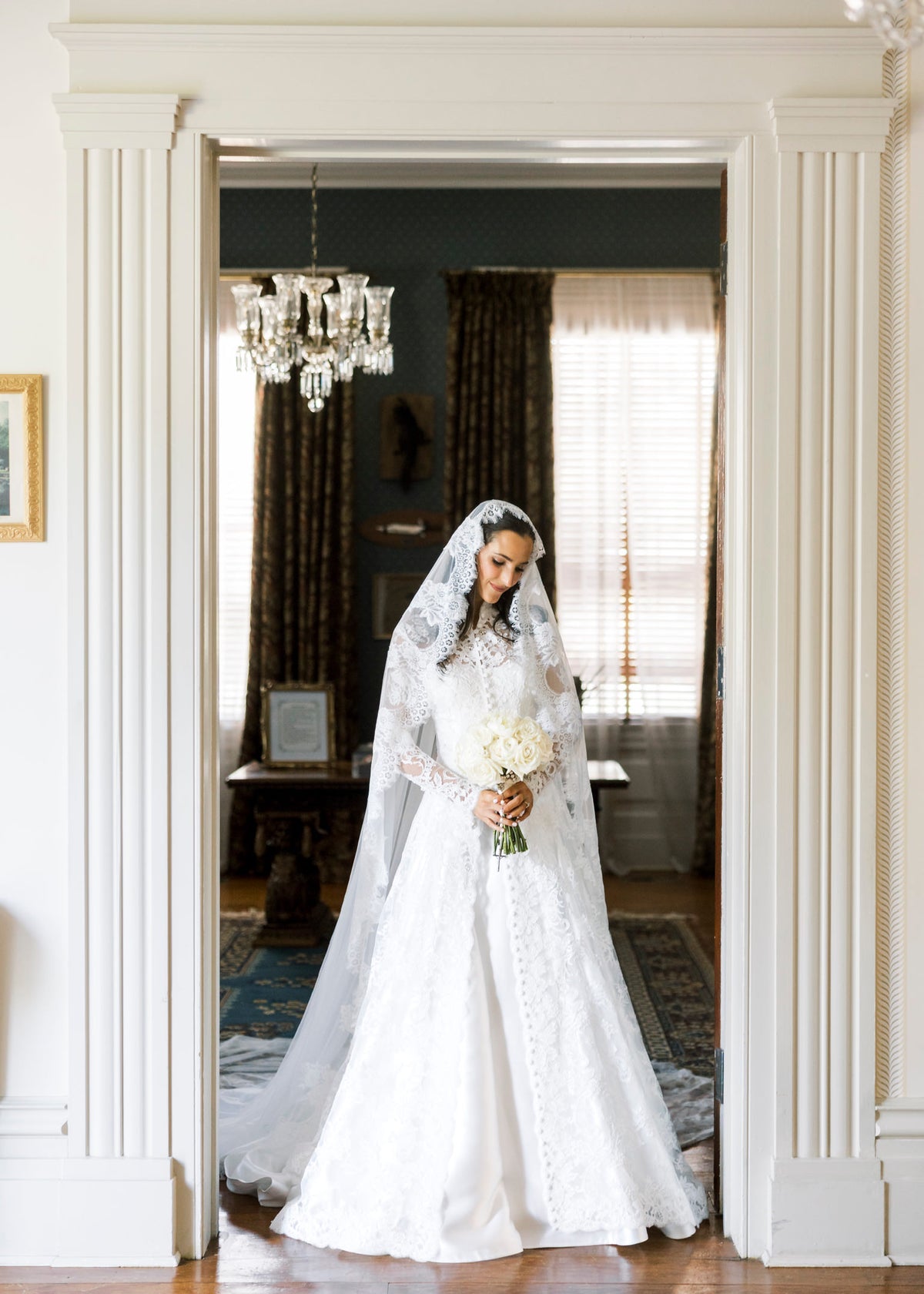 long sleeve lace bridal cape in ivory with buttons down front and matching lace mantilla bridal veil in downdo hair