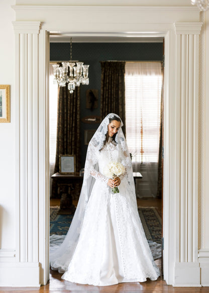 long sleeve lace bridal cape in ivory with buttons down front and matching lace mantilla bridal veil in downdo hair