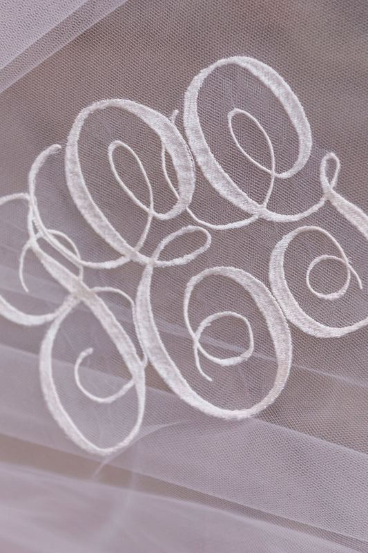 interlocking cursive script embroidered wedding veil with married couple's initials on tulle