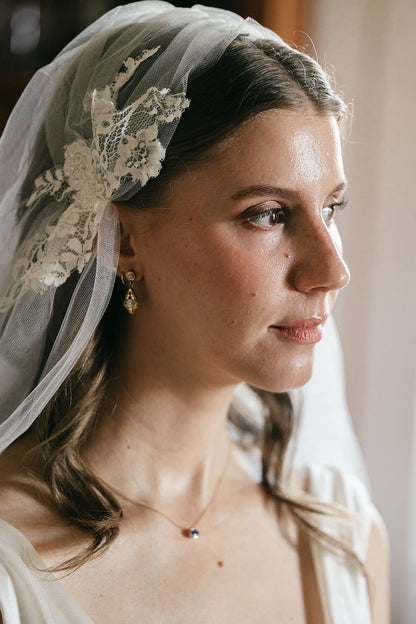 bride in Juliet cap vintage veil and gold drop earrings with natural makeup