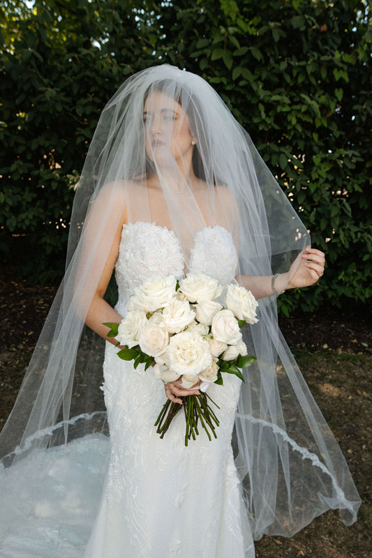 deep v neckline bridal gown with two layer wedding veil with lace edge