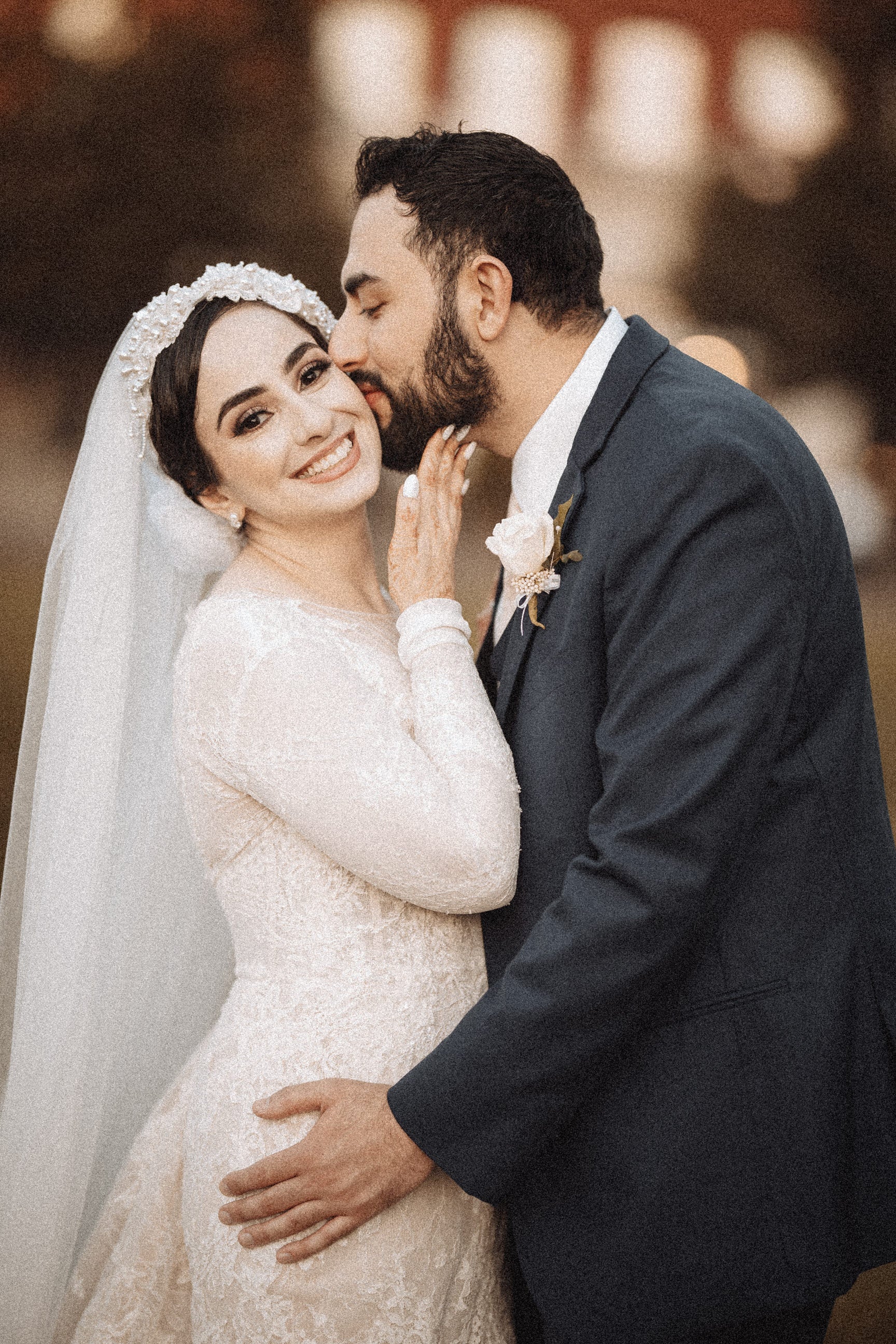 middle eastern bride wearing a hijabi lace bridal veil with pearls and long cathedral veil
