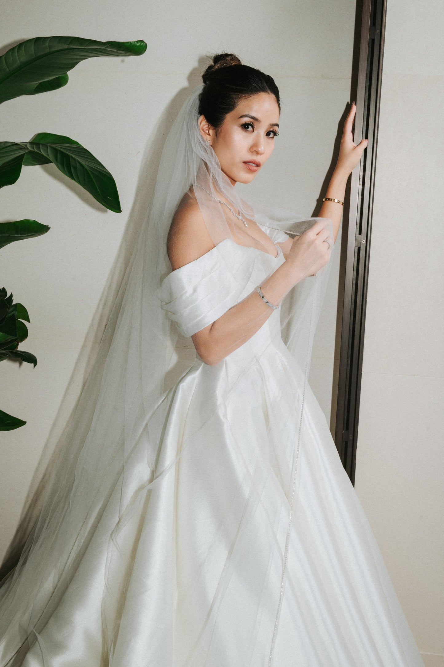 long bridal veil with crystal edges in high updo with off the shoulder sleeves