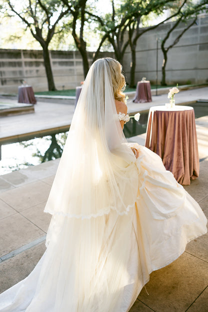 princess Diana inspired Bride in a vintage ivory wedding dress with a long  drop silk tulle veil and rosette sleeves