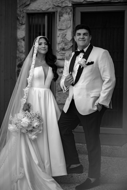 mexican bride and groom with bride in notched neck dress and lace eyelash mantilla veil over glam curls