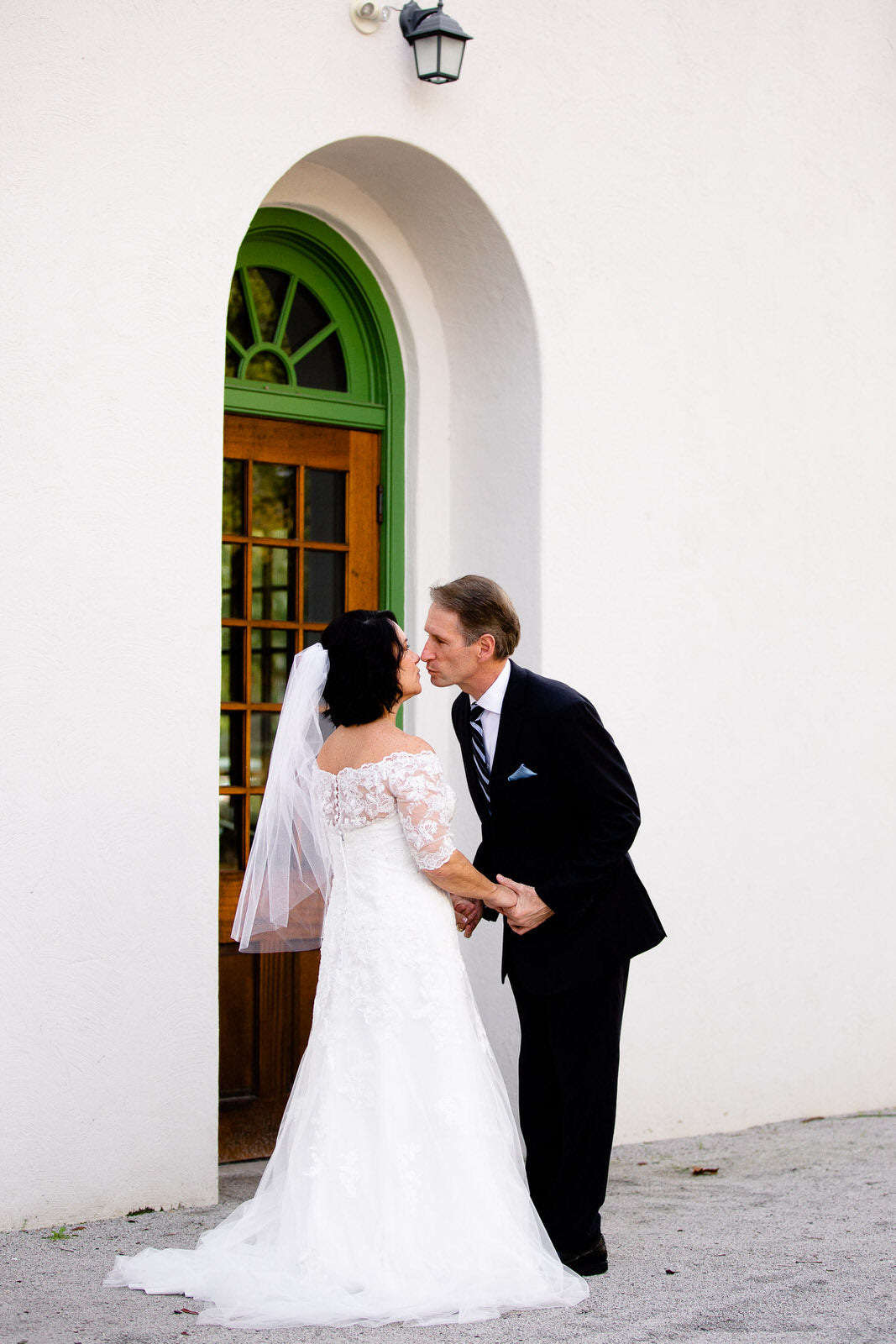 classic bride in off the shoulder lace dress with raw edge fingertip length veil