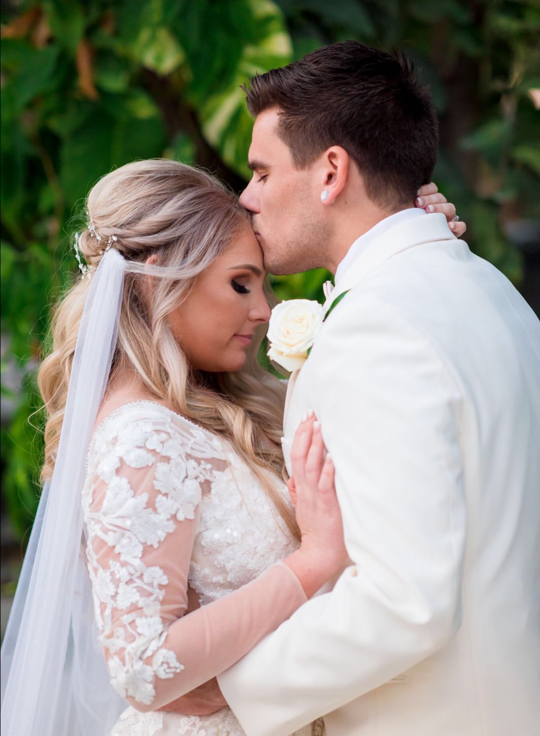 long sleeved wedding dress and white silk draped cape veil