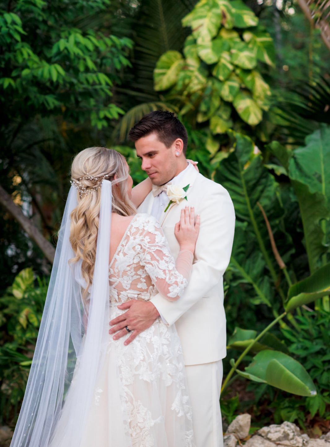 romantic beach wedding with bride in draped cape veil in her half up hairstyle