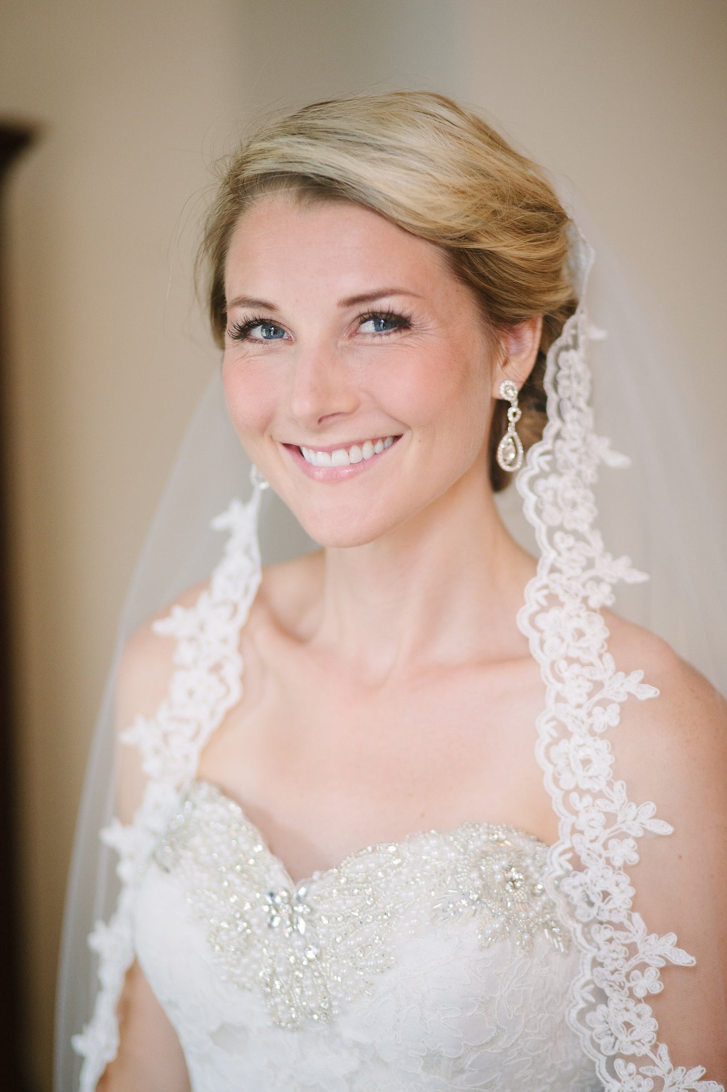 Elegant Bridal Updo With French Alencon Lace Wedding Veil and Drop Earrings