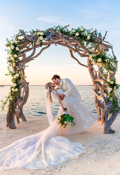 blush beach wedding with natural twig alter and bride wearing draped cape veil 