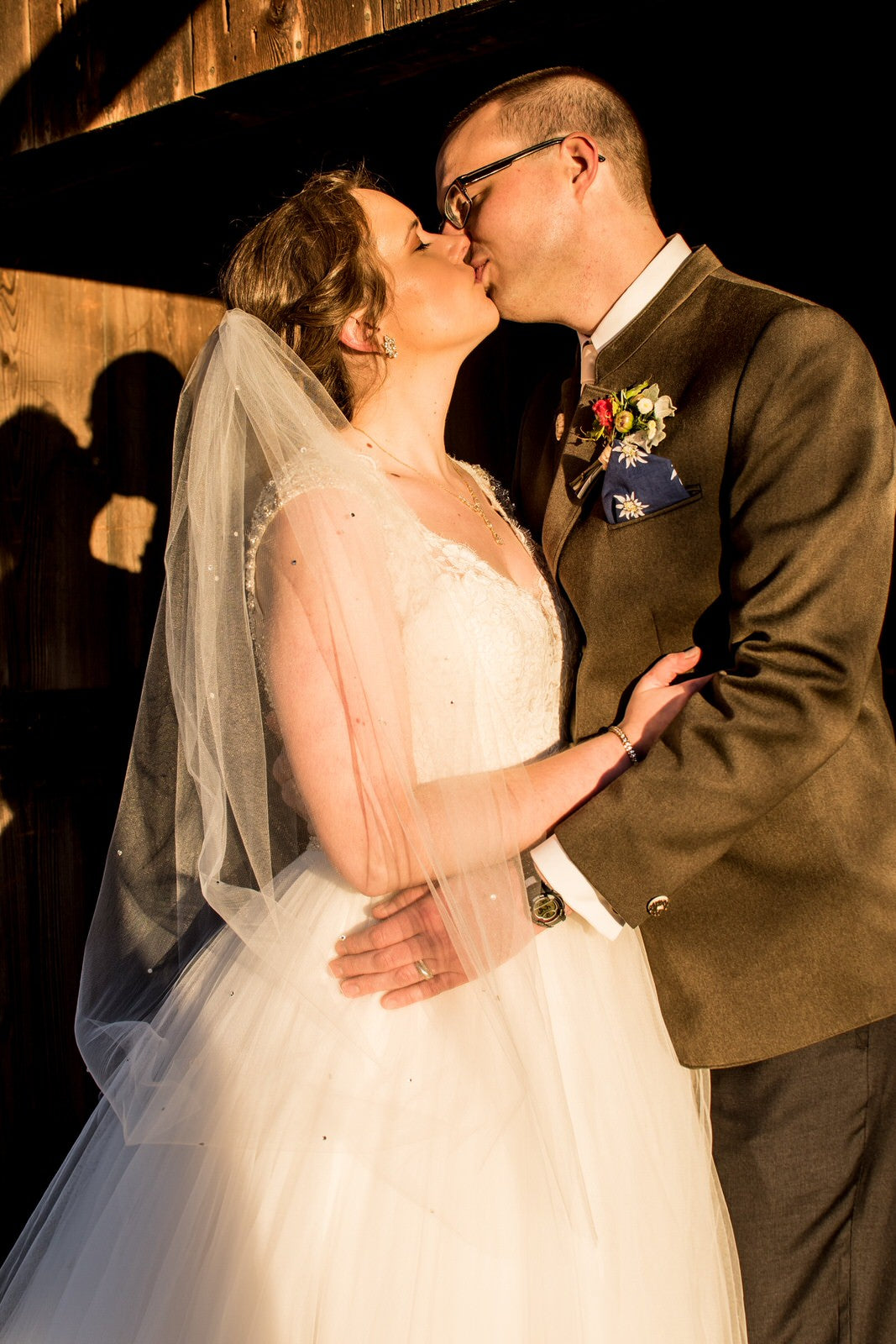 rustic groom with bride in rhinestone fingertip length wedding veil