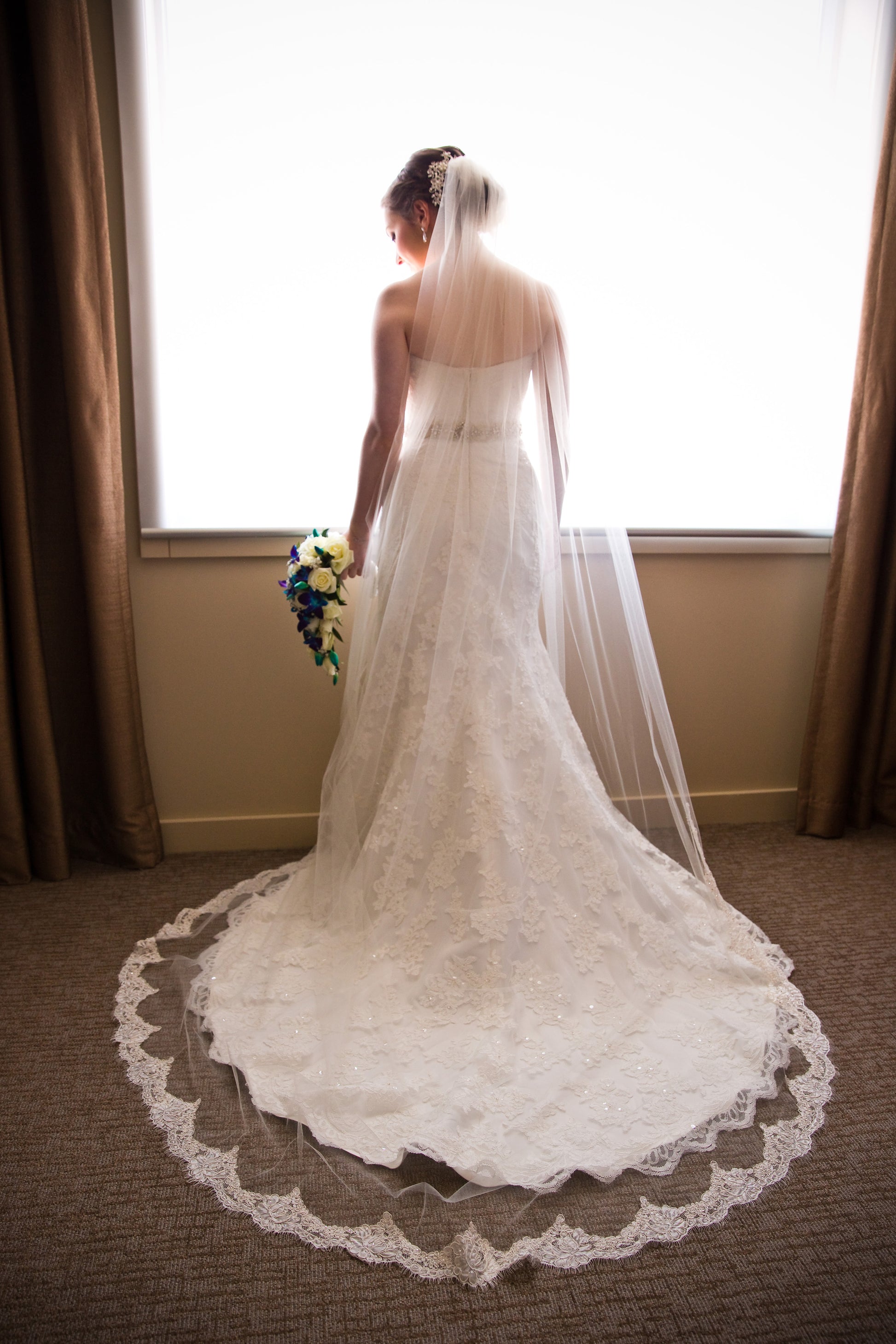 romantic eyelash edged cathedral length wedding veil framing A line lace wedding dress on bride