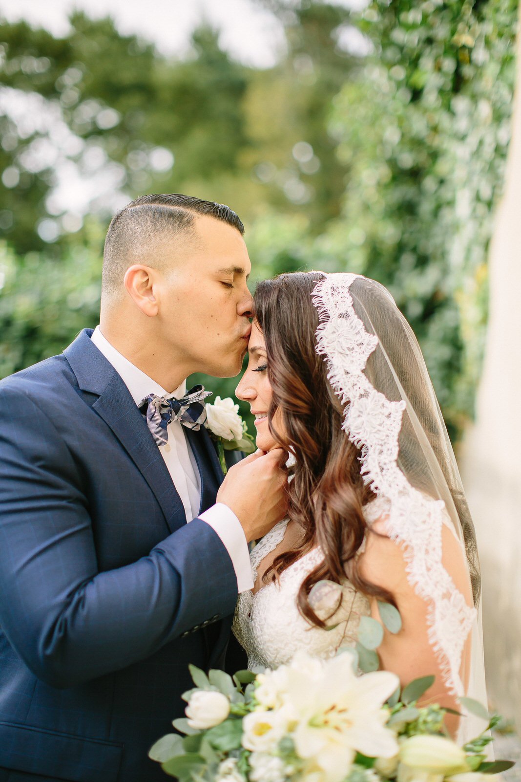 mantilla lace veil in downdo with groom kissing bride