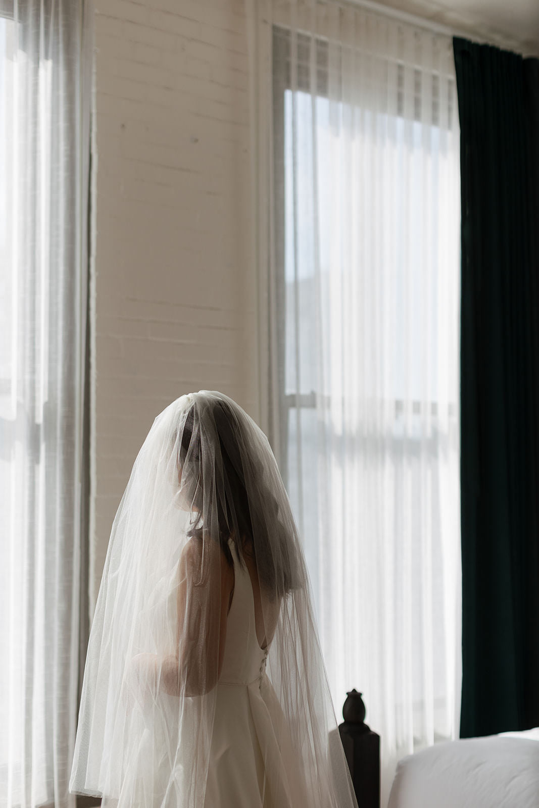 bride wearing two layer blusher wedding veil and scoop back bridal gown with wavy hair down