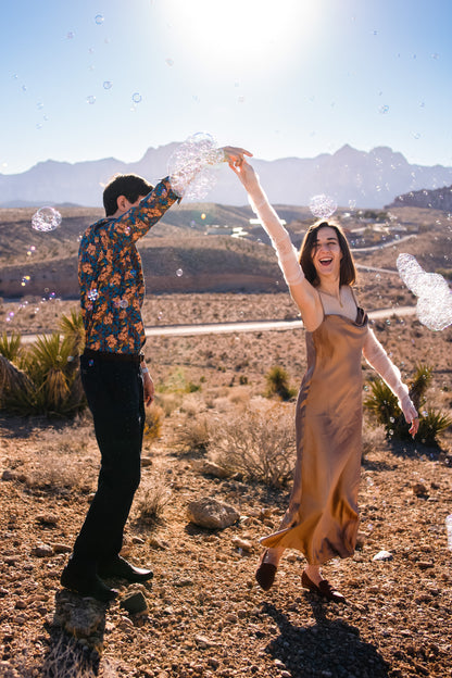 gold desert engagement photo featuring long white fingerless gloves with Tull death embroidery