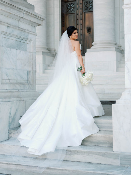 black tie formal wedding with bride wearing extra full and puffy cathedral long bridal veil over low updo